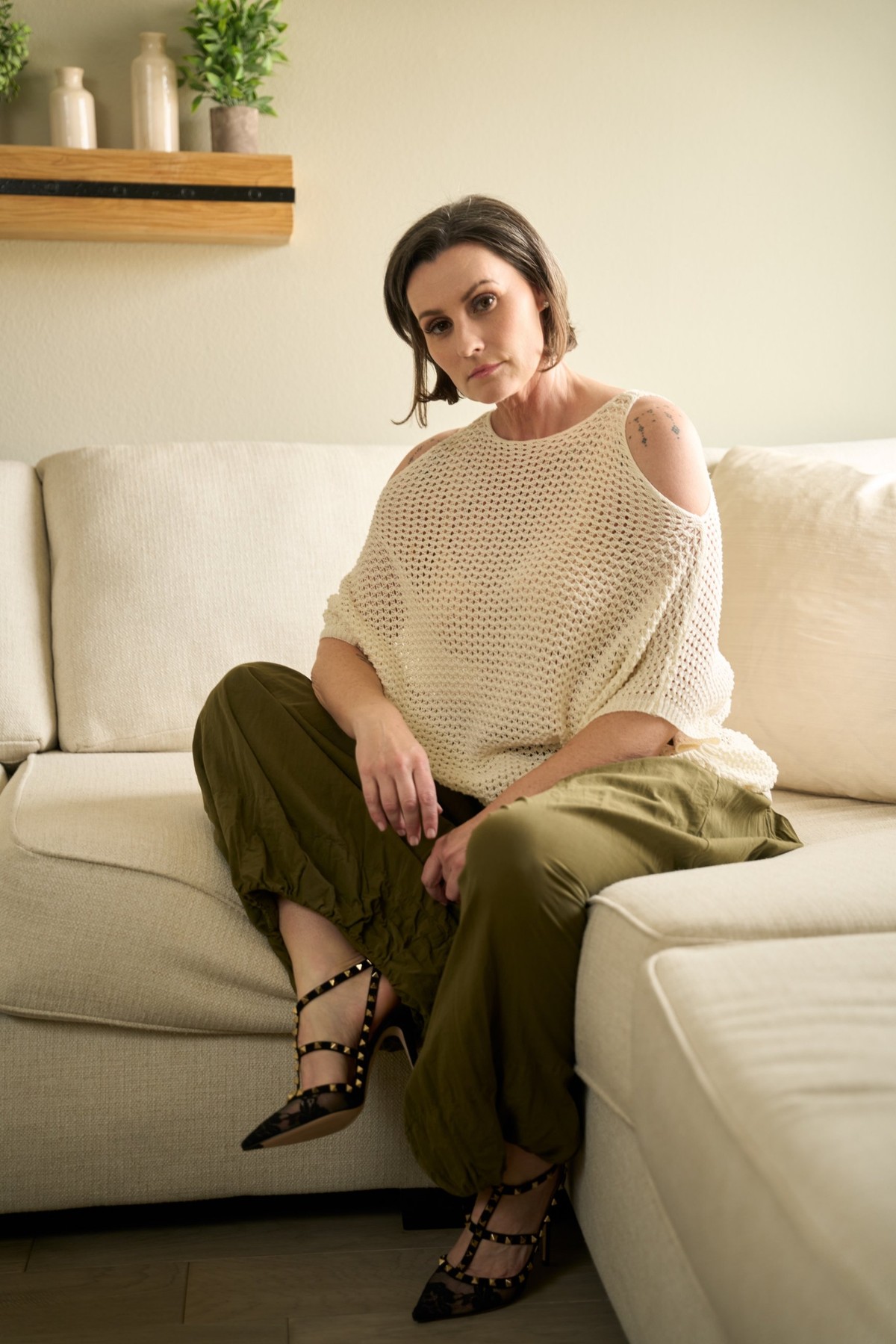 Melody Jai with a short brown bob, seated on a cream sofa